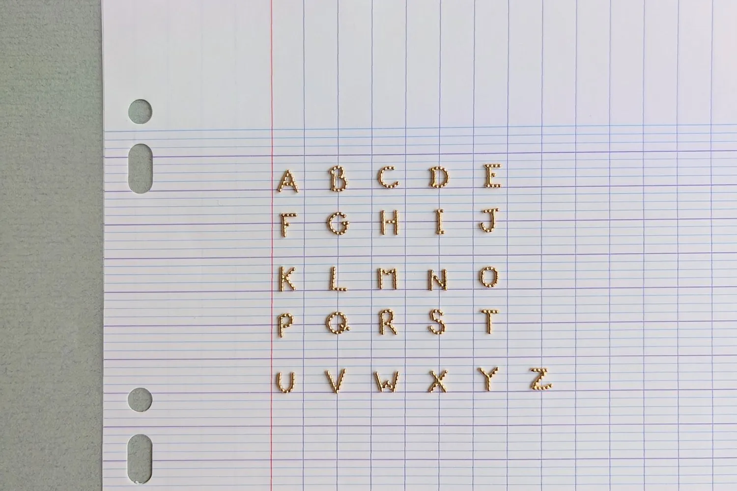Les vingt-six lettres de la collection Alpha Letters posées sur une feuille