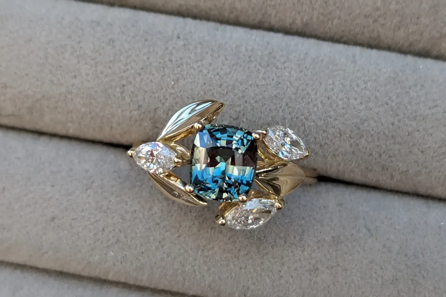 Bague saphir bleu-vert dans un feuillage d'or, diamants taille navette